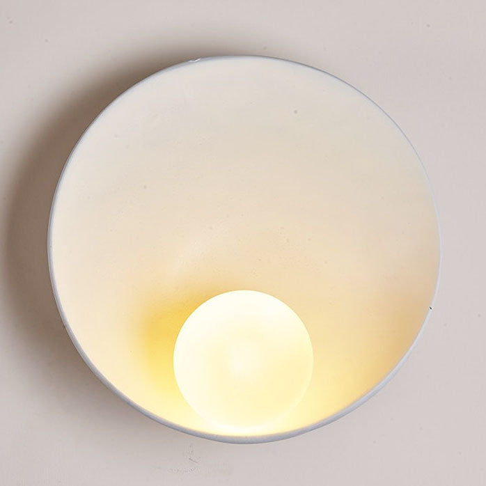 Round resin wall light lit on wall