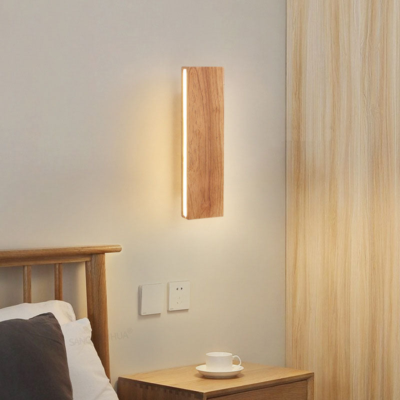Small wood LED wall light beside a bed