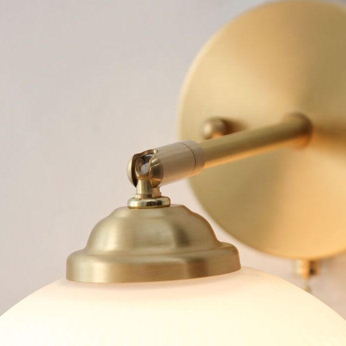 Striped glass wall light beside a bed