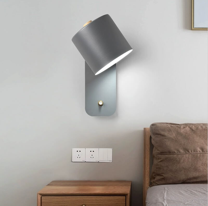 Cylinder wall light beside a bed