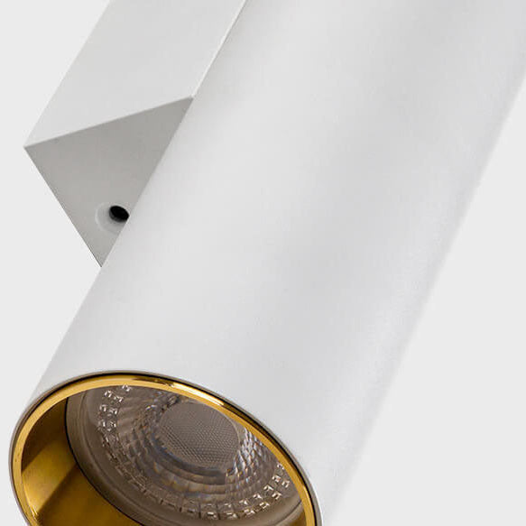 Cylinder wall light beside a mirror