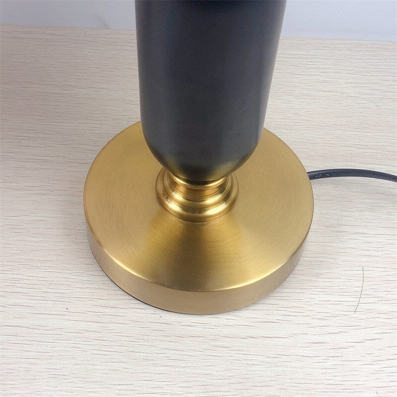 Pleated shade table lamp lit on bedside table