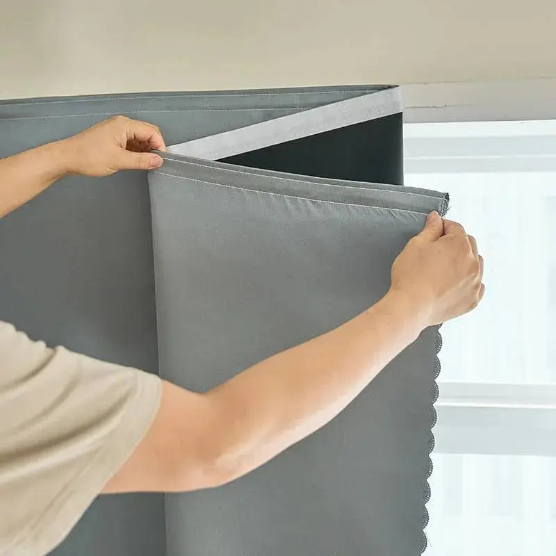 Grey self-adhesive blackout curtain on a window