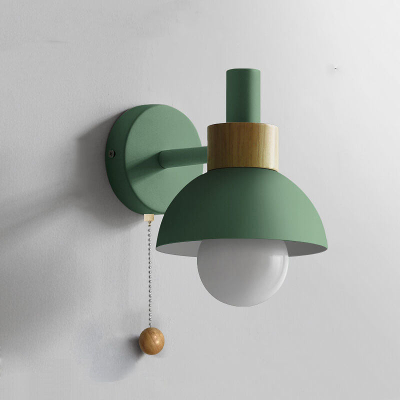 Macaron globe wall light beside a bed