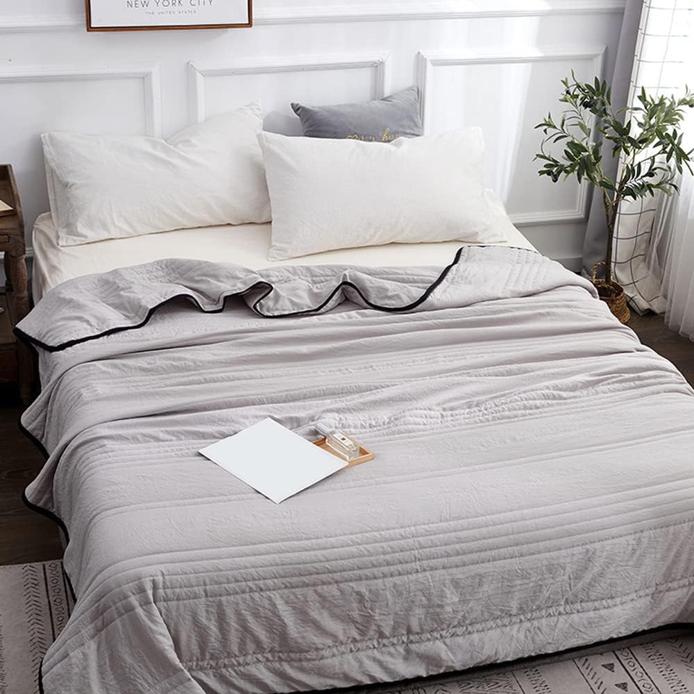 Cooling blanket in grey on a bed
