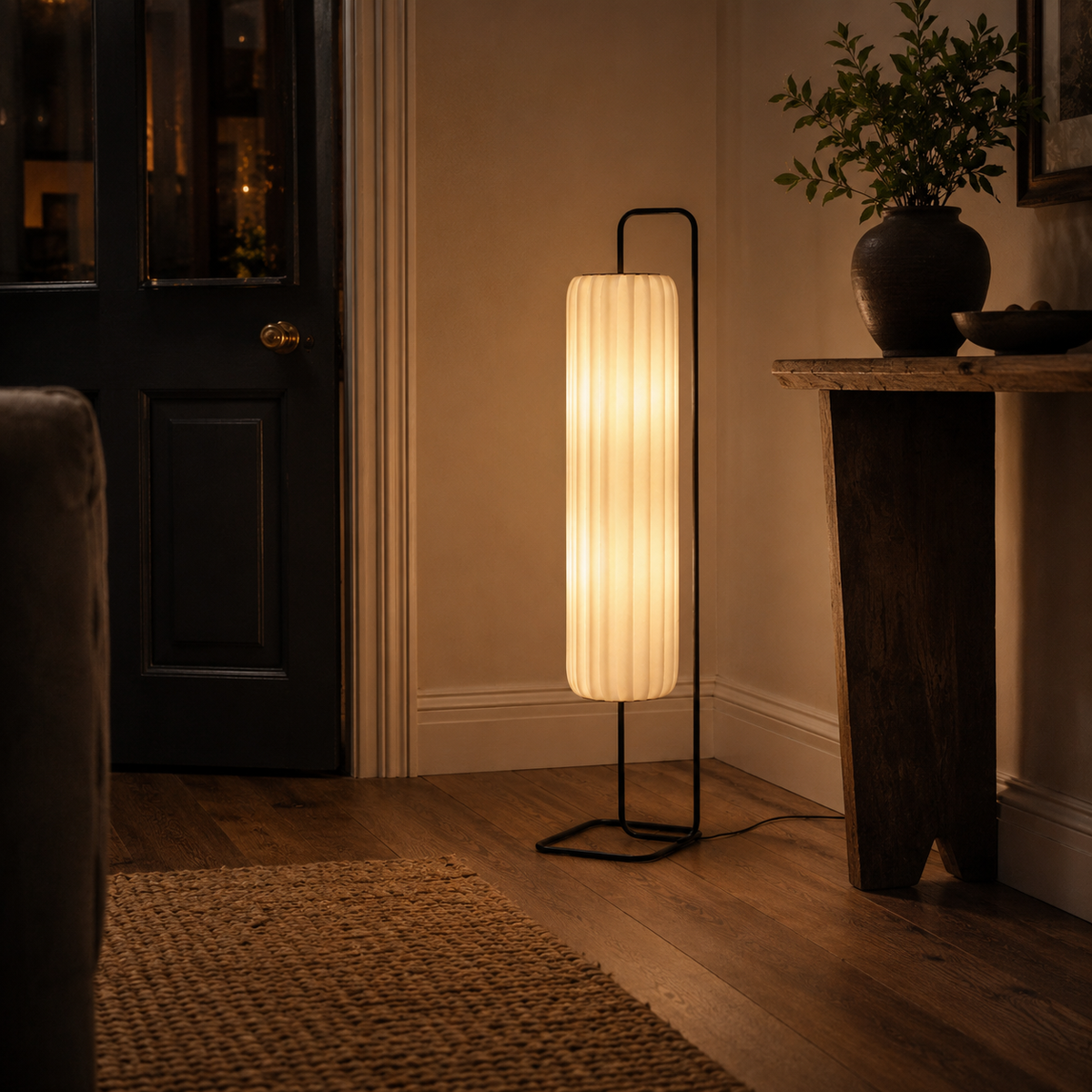 Fabric floor lamp glowing softly beside a sofa