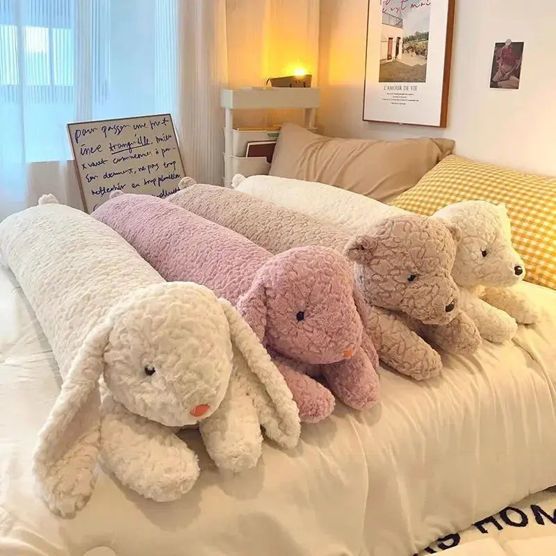Long plush rabbit body pillow on a bed