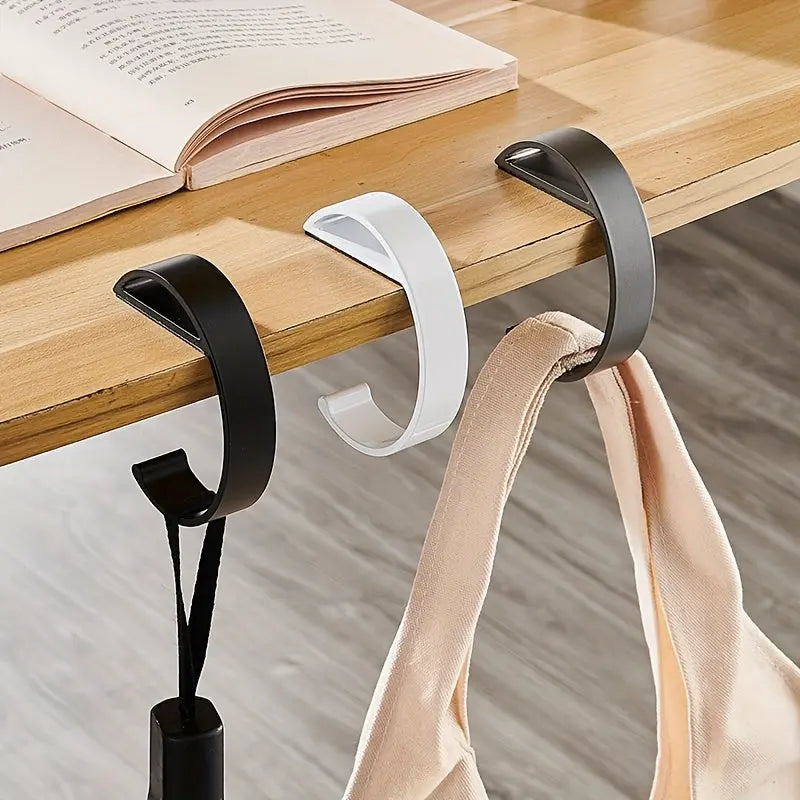 C-shaped desk hook holding a handbag