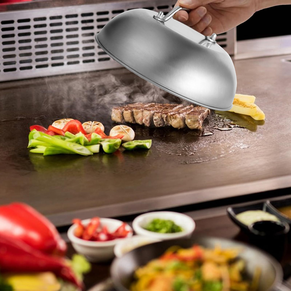 Stainless steel griddle dome over a burger on a flat-top grill